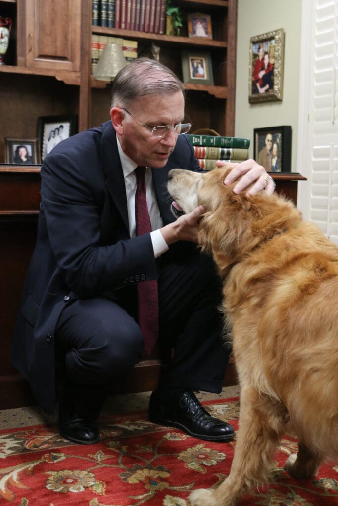 attorney loving on golden retriever in law office